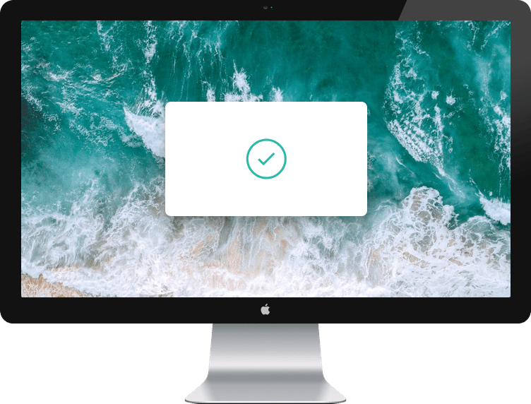 Computador Mac con un fondo de las olas de una playa y una ventana emergente con un check